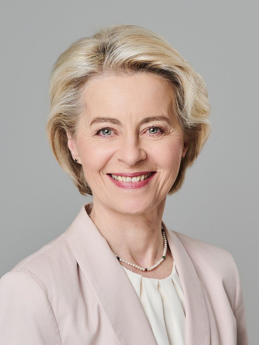 Head-and-shoulders portrait of a smiling woman against pale grey background